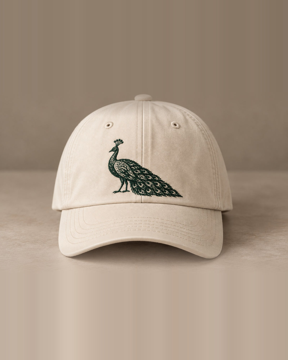 Cremefarbene Cap Hausrecht von vorne mit Pfau in Dunkelgrün